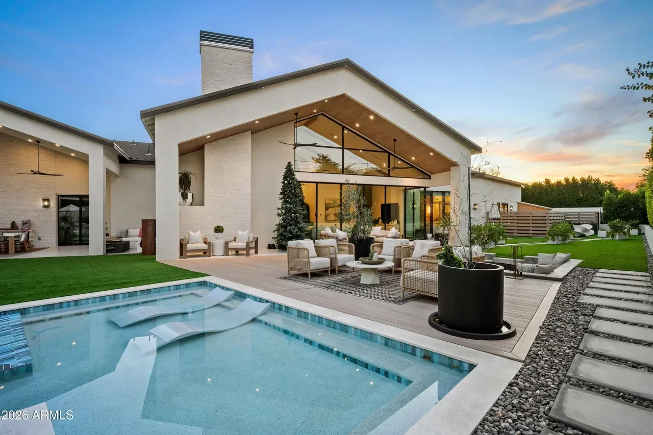 Modern home with white brick, large glass walls, pool, and composite deck patio