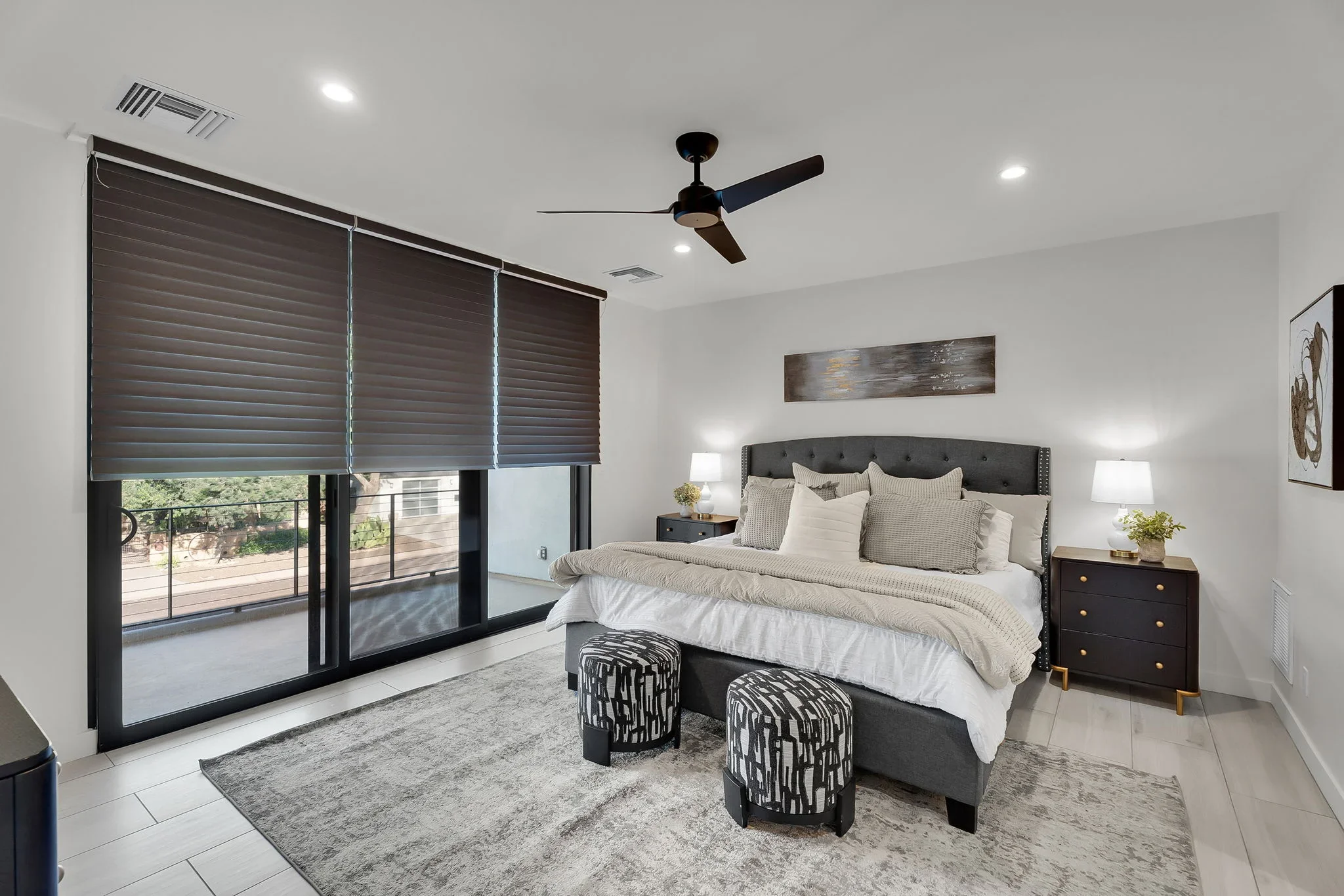 Master bedroom with black sliding glass doors, motorized shades, recessed lighting, and ceiling fan